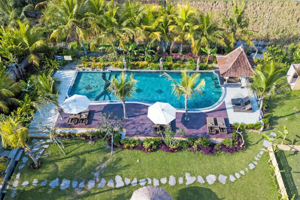 an aerial view of a resort swimming pool with palm trees at Ubud Art Resort in Ubud