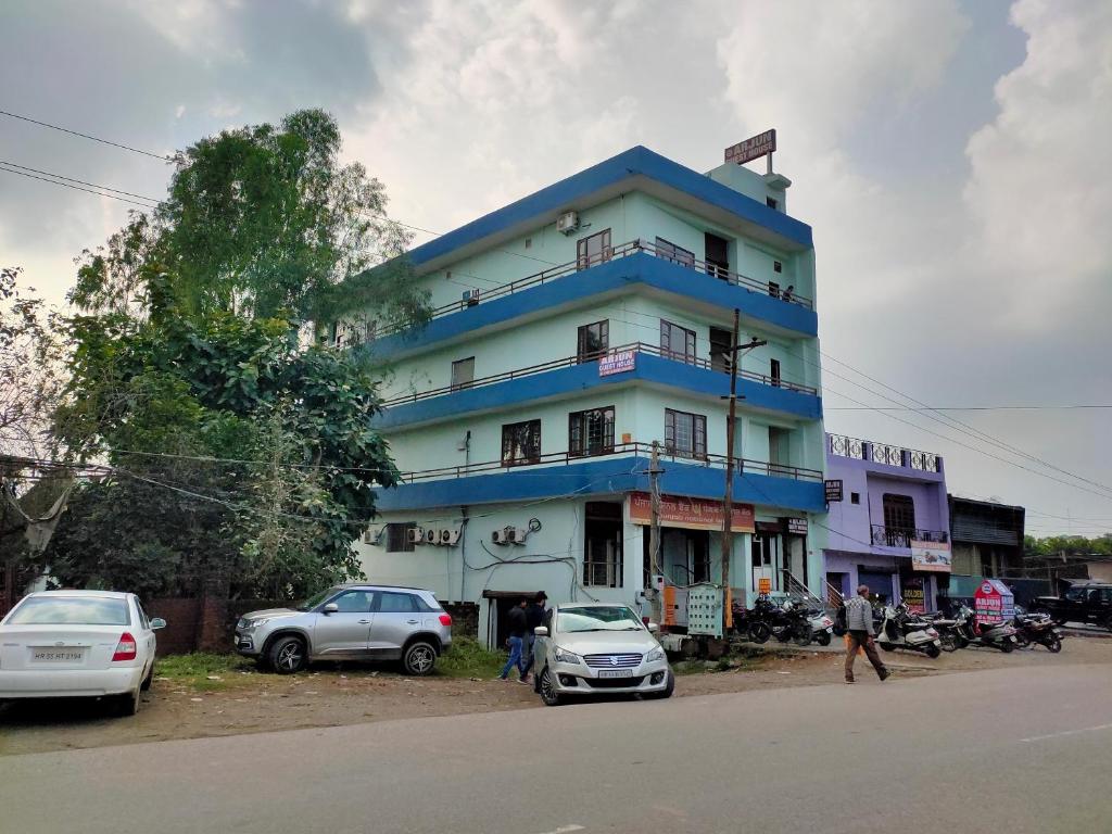 a blue building with cars parked in front of it at ARJUN GUEST HOUSE in Pathānkot