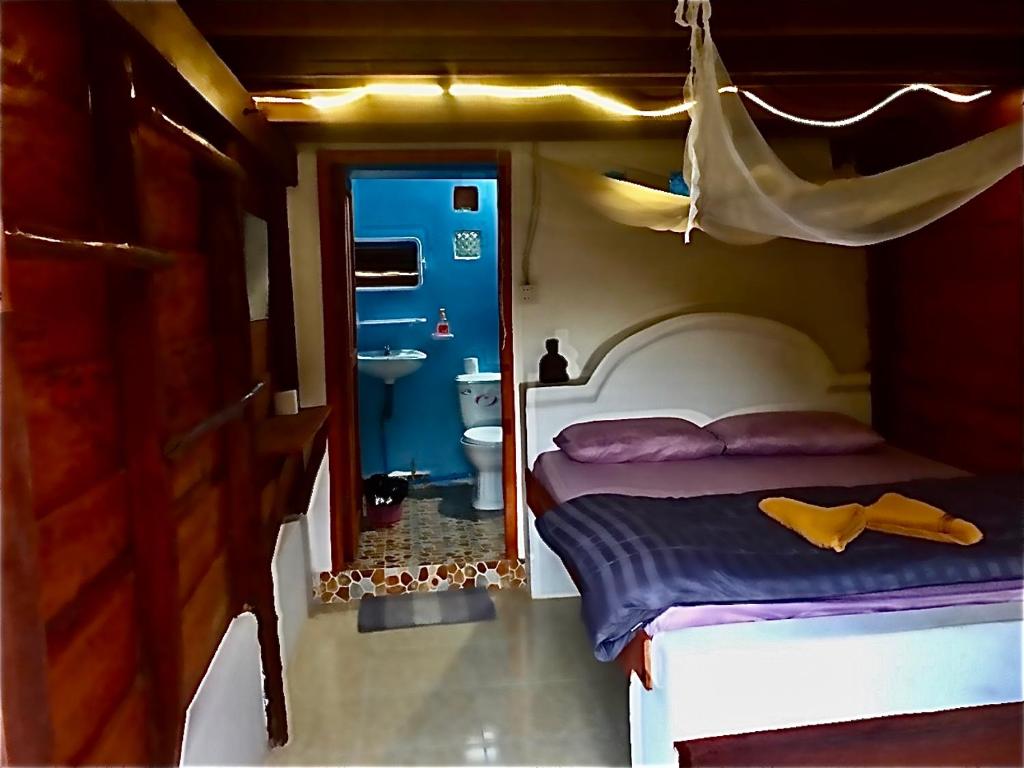 a bedroom with a bed and a bathroom with a sink at Lazy Bones in Koh Rong Sanloem