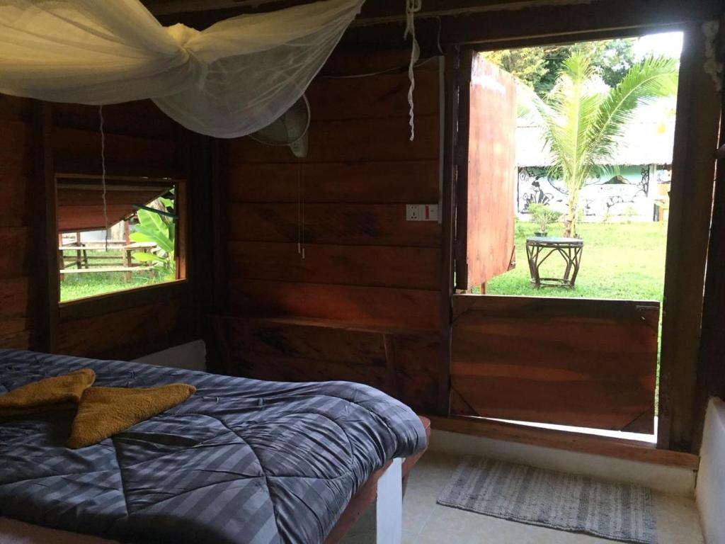a bedroom with a bed and a large window at Lazy Bones in Koh Rong Sanloem