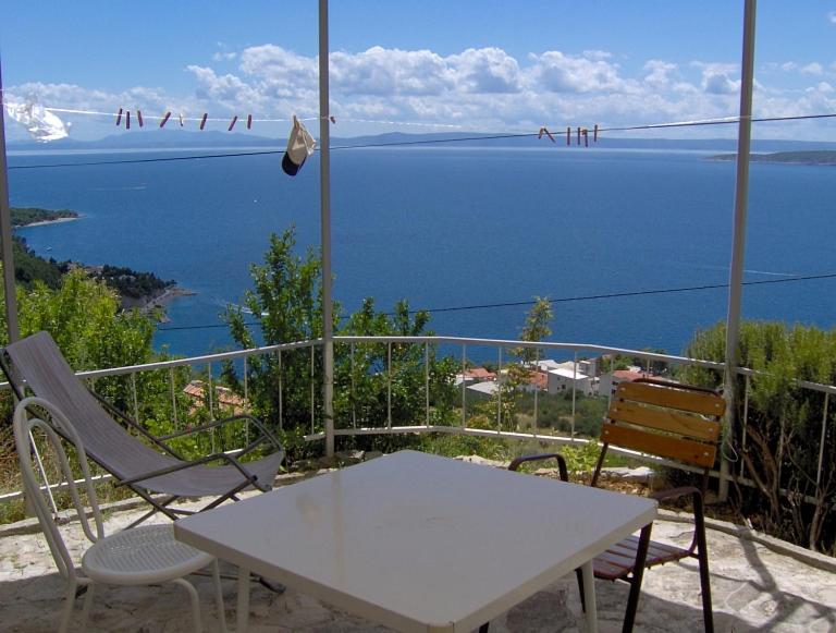 een tafel en stoelen op een balkon met uitzicht op het water bij Breathtaking sea view apartments Boris in Brela