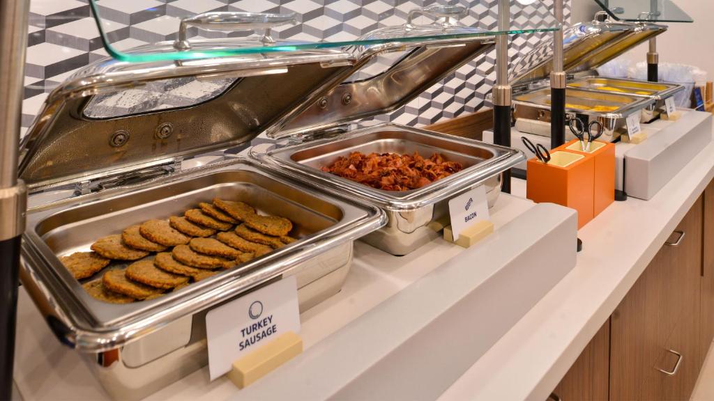 a buffet line with trays of cookies and other food at Holiday Inn Express and Suites Calgary by IHG in Calgary