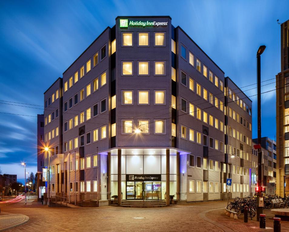 Un edificio alto y negro con un cartel. en Holiday Inn Express Arnhem, an IHG Hotel en Arnhem