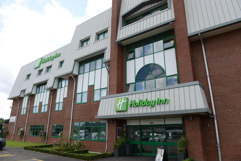 a large brick building with a healthcare sign on it at Holiday Inn Wolverhampton - Racecourse, an IHG Hotel in Wolverhampton