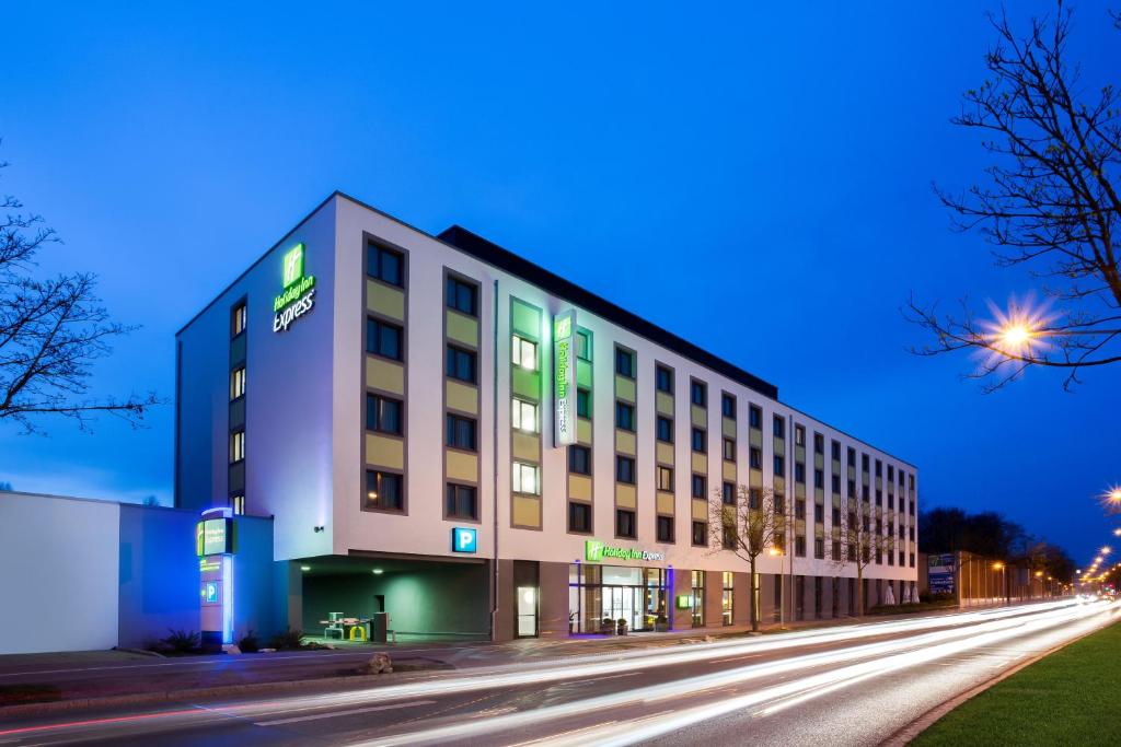 a large building on a city street at night at Holiday Inn Express Augsburg, an IHG Hotel in Augsburg
