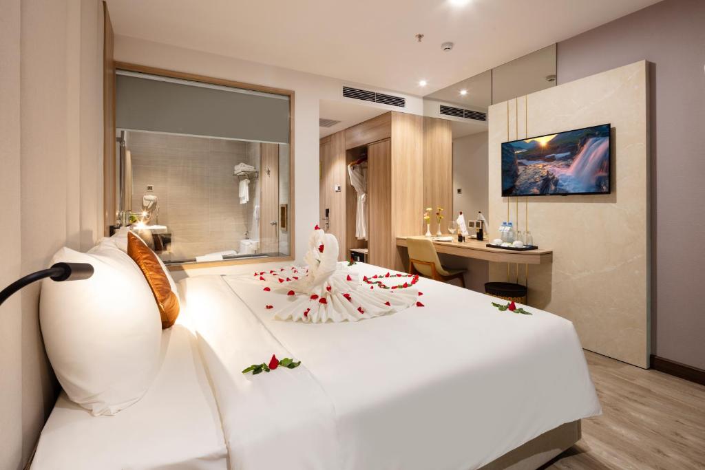 um quarto com uma grande cama branca com flores em Nalicas Nha Trang Hotel em Nha Trang
