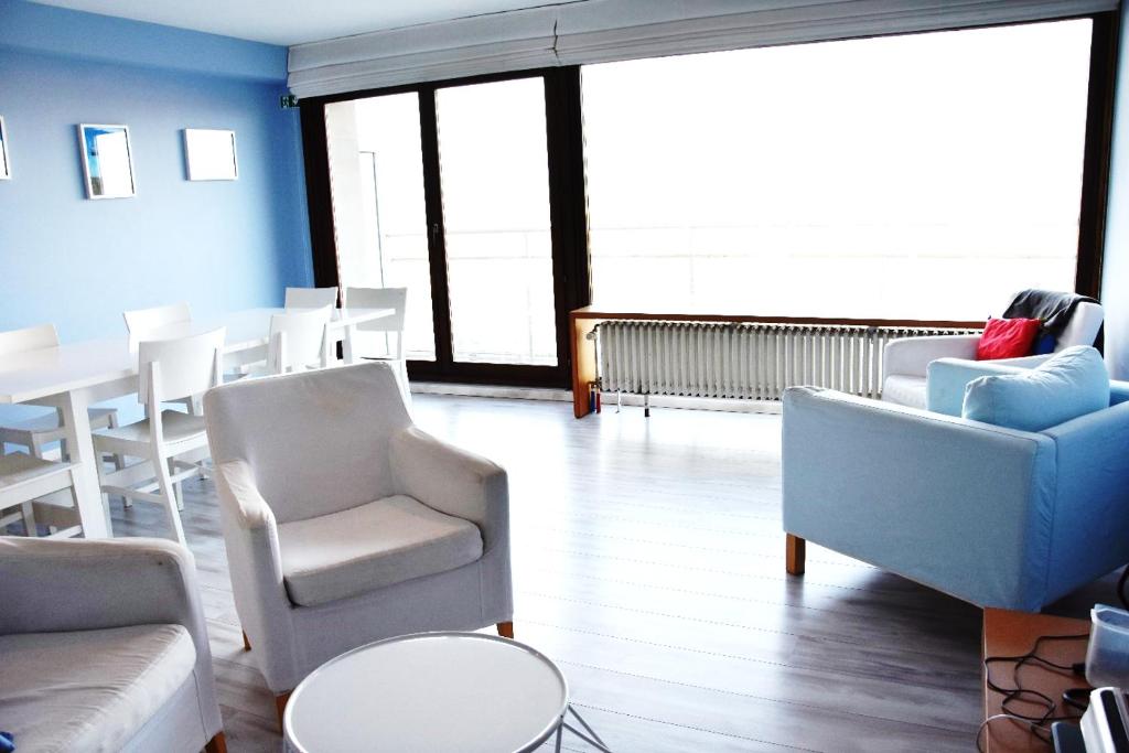 een woonkamer met banken en stoelen en een tafel bij Thalassa 15 in Zeebrugge