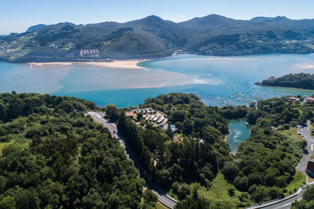 - une vue aérienne sur un complexe au bord d'un lac dans l'établissement Bungalows Portuondo parking gratuito, à Mundaka