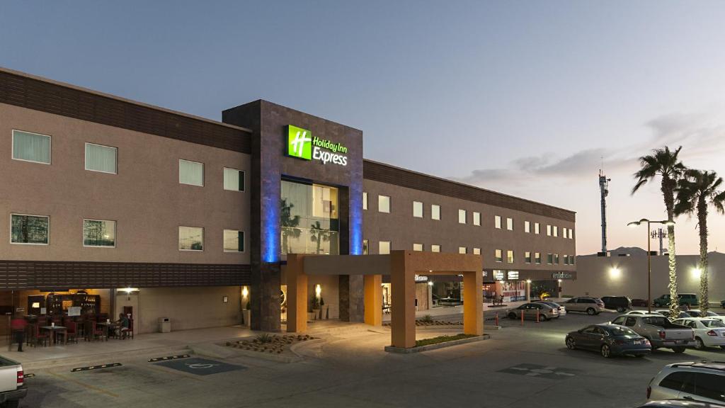 a hotel with a parking lot with cars parked at Holiday Inn Express Cabo San Lucas, an IHG Hotel in Cabo San Lucas