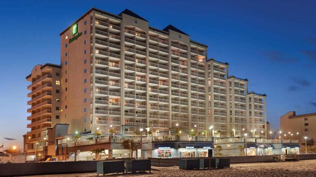 オーシャンシティにあるHoliday Inn & Suites Ocean City, an IHG Hotelのビーチ沿いに多くのバルコニーが付いた大きな建物