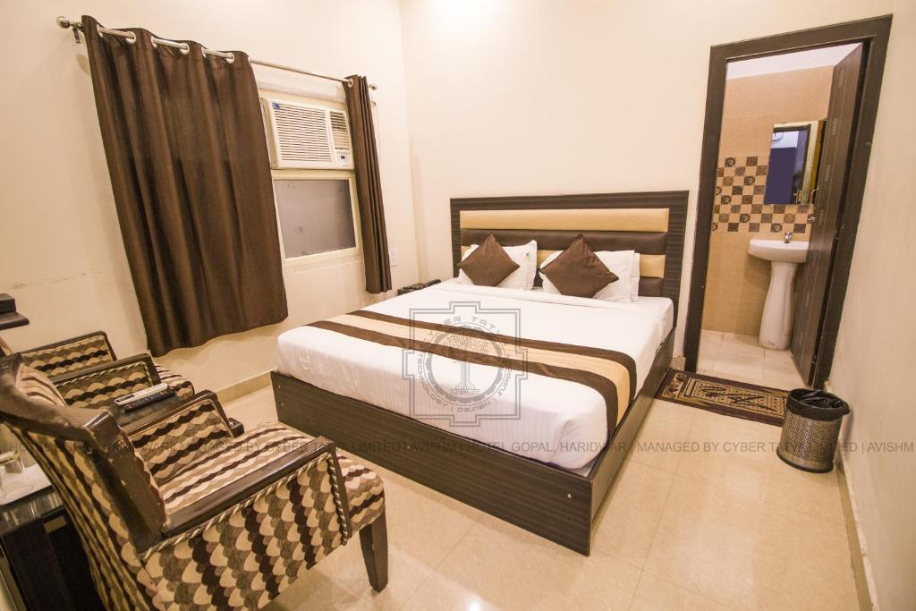 - une chambre avec un lit, une chaise et un lavabo dans l'établissement Hotel Gopal, à Haridwar