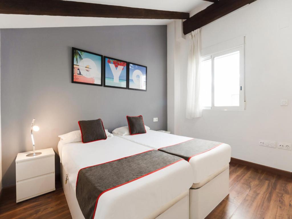 a bedroom with a large white bed and a window at OYO Style Apartments Puerto in Valencia