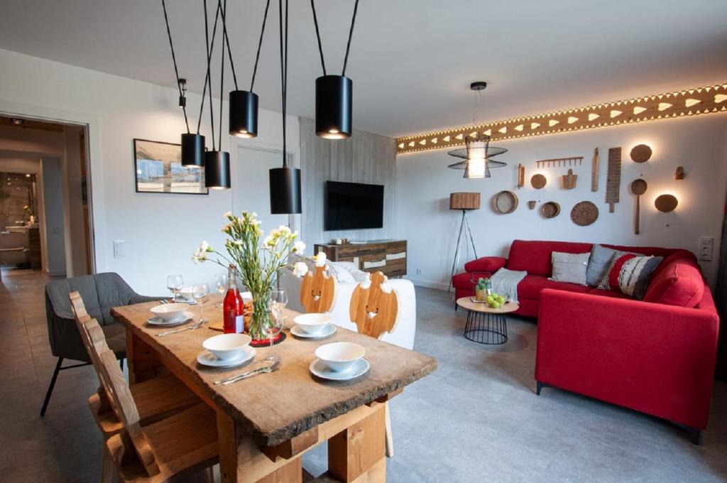 a living room with a table and a red couch at Apart-Center Przy Krupówkach in Zakopane