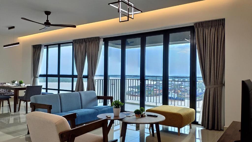 sala de estar con sofá azul y ventanas grandes en Waterfront 3BR 3Bath, en Sibu