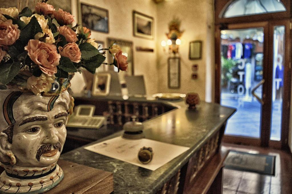 a vase filled with flowers sitting on top of a counter at Hotel Victoria in Taormina