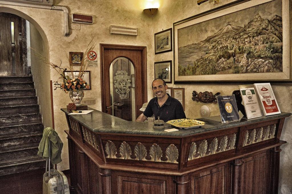 a man sitting at a bar in a room at Hotel Victoria in Taormina