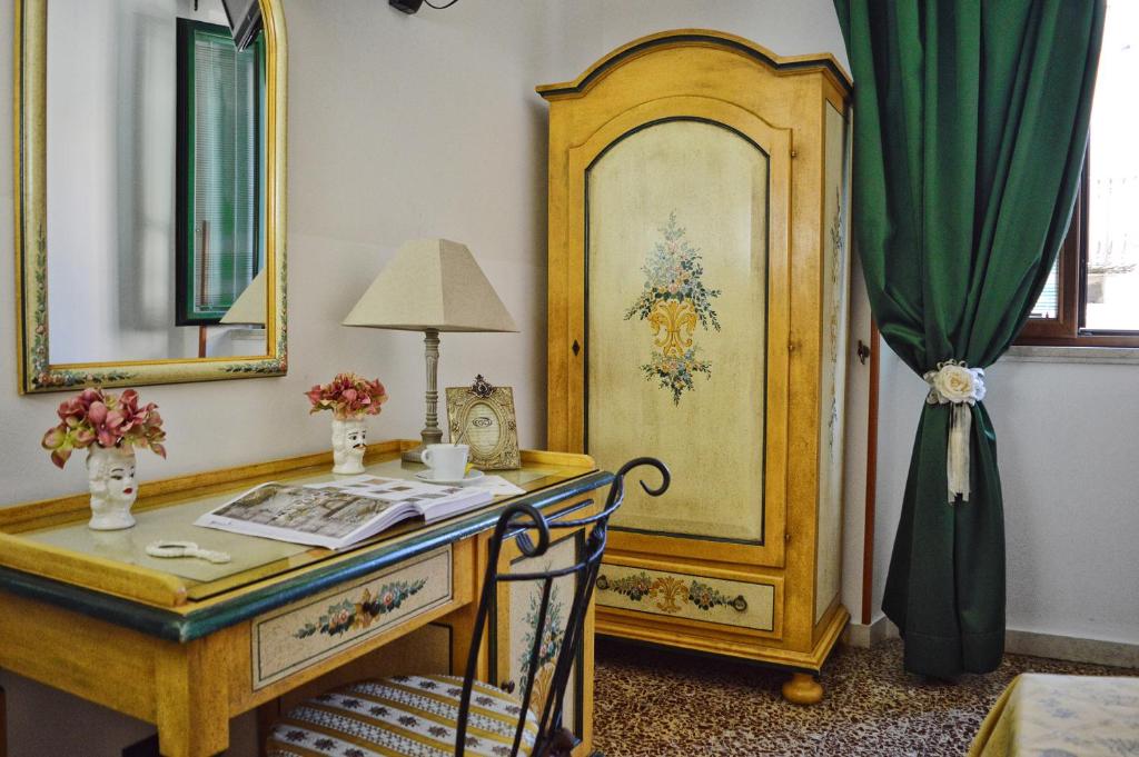 a room with a desk and a mirror at Hotel Victoria in Taormina