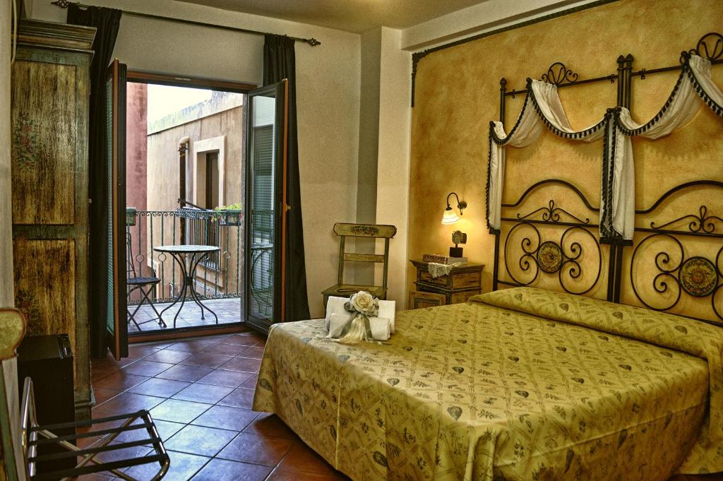 a bedroom with a large bed and a balcony at Hotel Victoria in Taormina