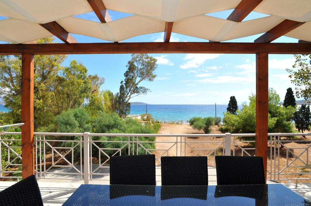 a view of the ocean from a patio with a table and chairs at Porto Assini in Tolo