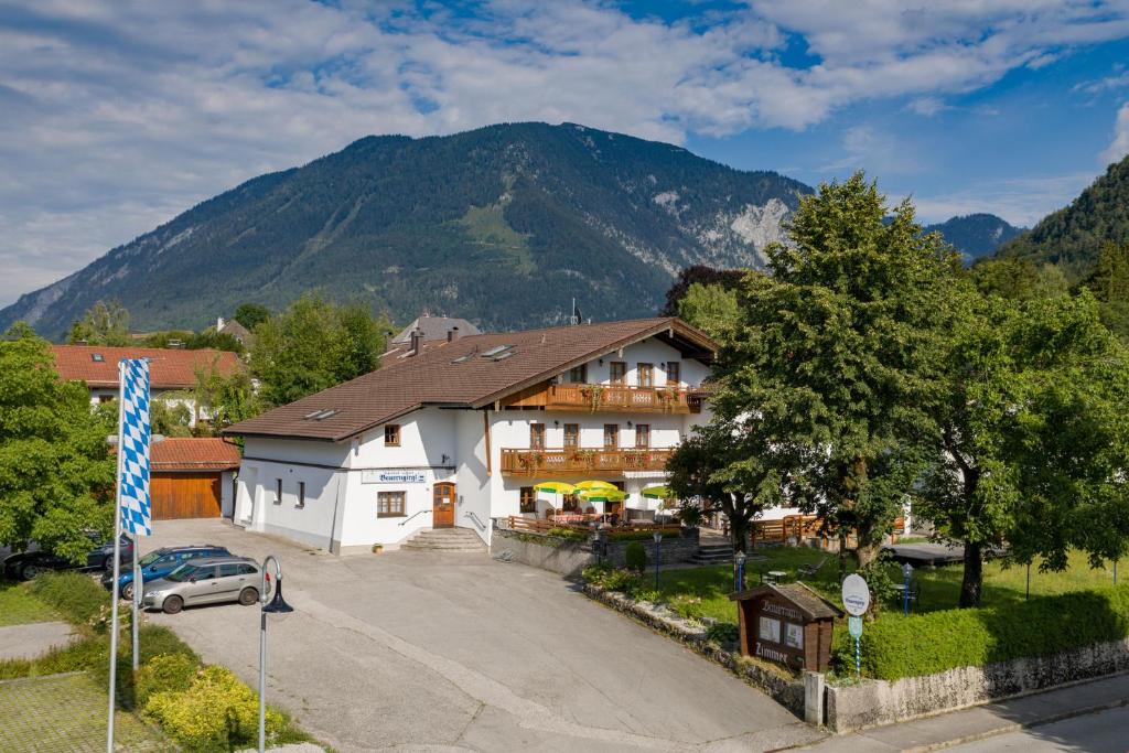 a large building with a mountain in the background at Landgasthof Bauerngirgl in Bayerisch Gmain