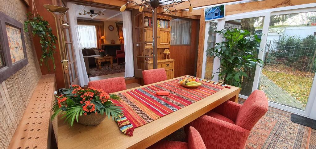 une table et des chaises en bois dans une petite maison dans l'établissement Knus chalet midden in de natuur en de rust., à Wageningue