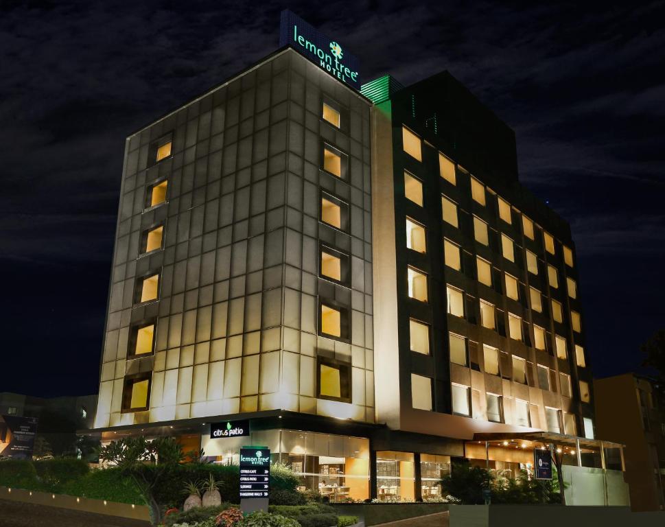 a hotel building with a sign on top of it at Lemon Tree Hotel Viman Nagar Pune in Pune