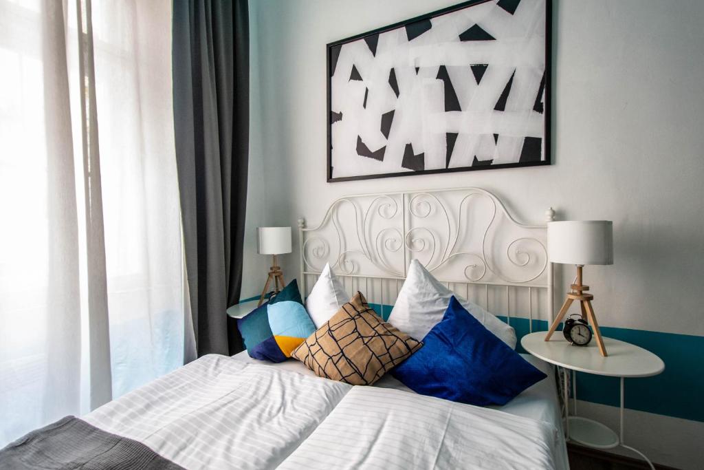 a bedroom with a bed with blue and white pillows at Sweet Home by Ruterra in Prague