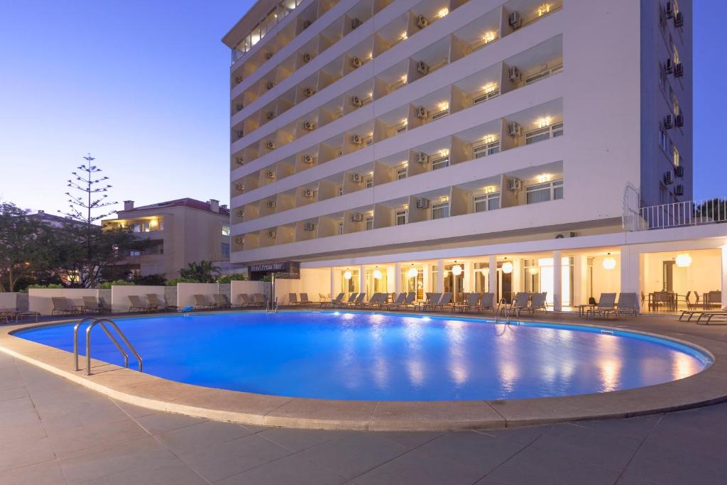 uma grande piscina em frente a um hotel em Carcavelos Beach Hotel em Carcavelos