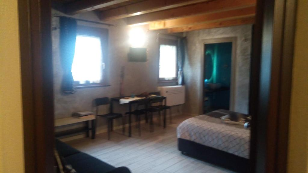 アオスタにあるLe Relais du Relaxのベッドルーム1室(ベッド1台、テーブル付)、ダイニングルームが備わります。