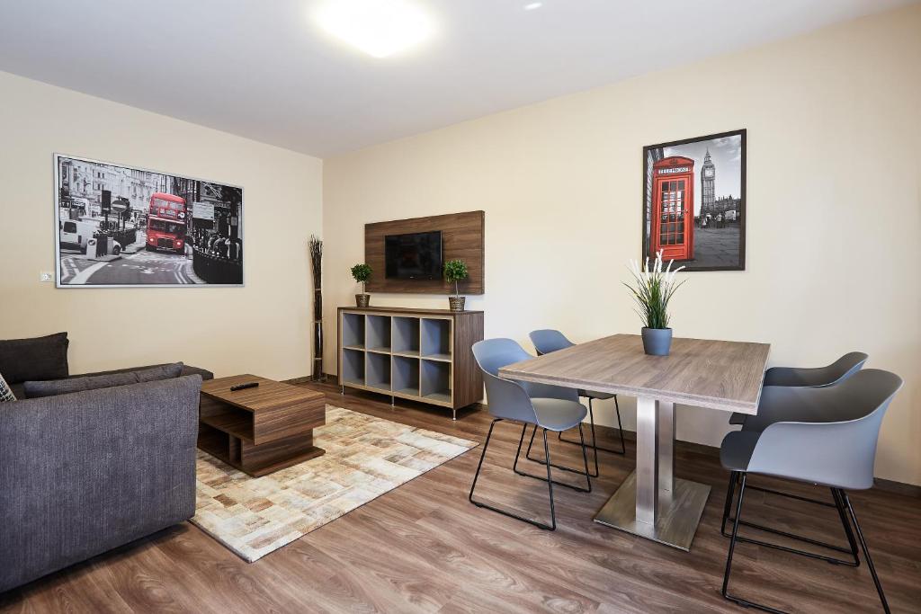 sala de estar con mesa y sofá en Óvár Apartman, en Mosonmagyaróvár