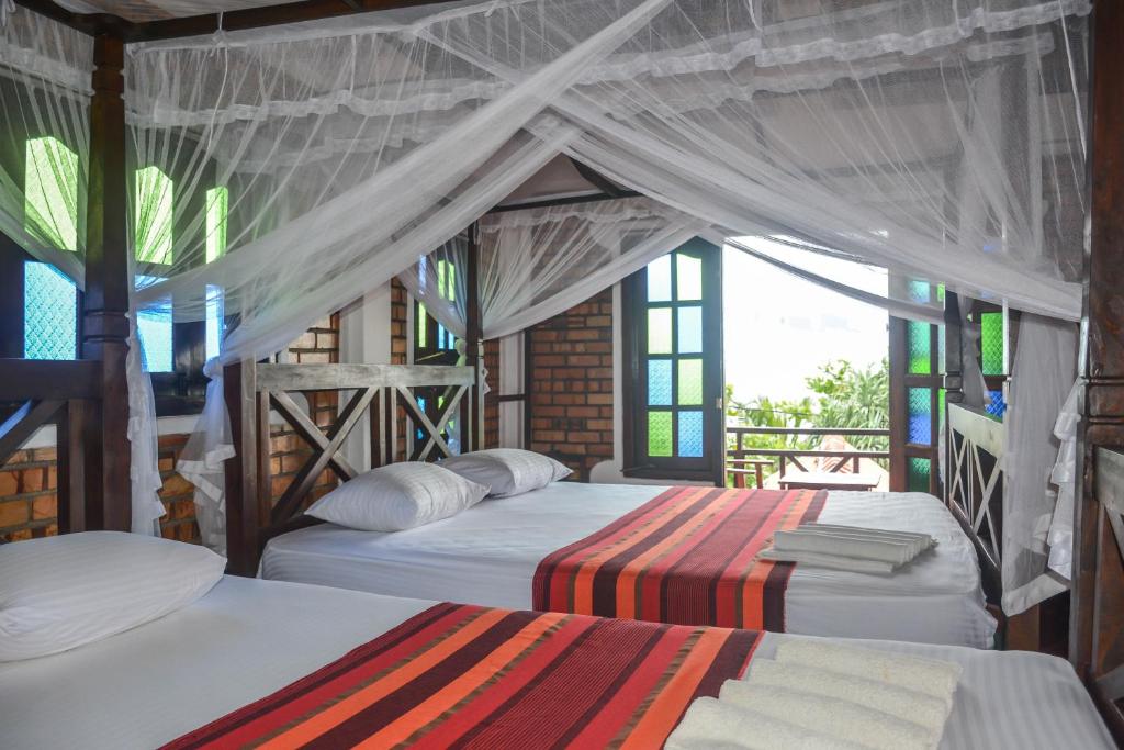 Säng eller sängar i ett rum på Blue Horizon Beach Hotel