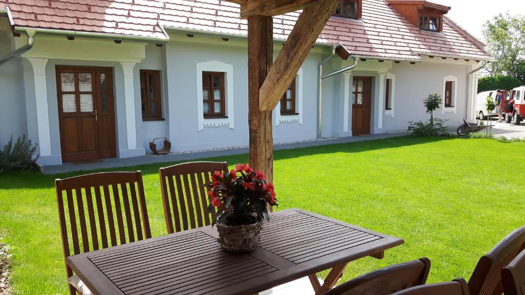 a wooden table with a vase of flowers on it at Arácsi Vendégház in Balatonfüred