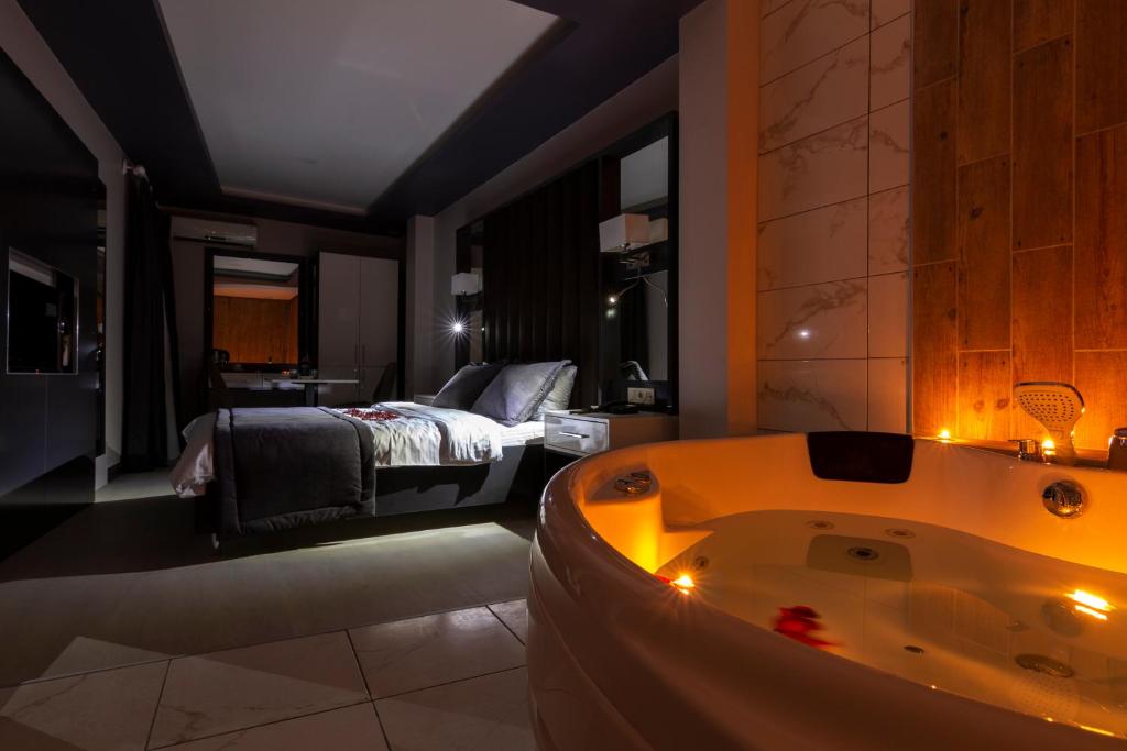 a bathroom with a tub and a bedroom with a bed at Bakırköy Zeugma Suit Otel in Istanbul