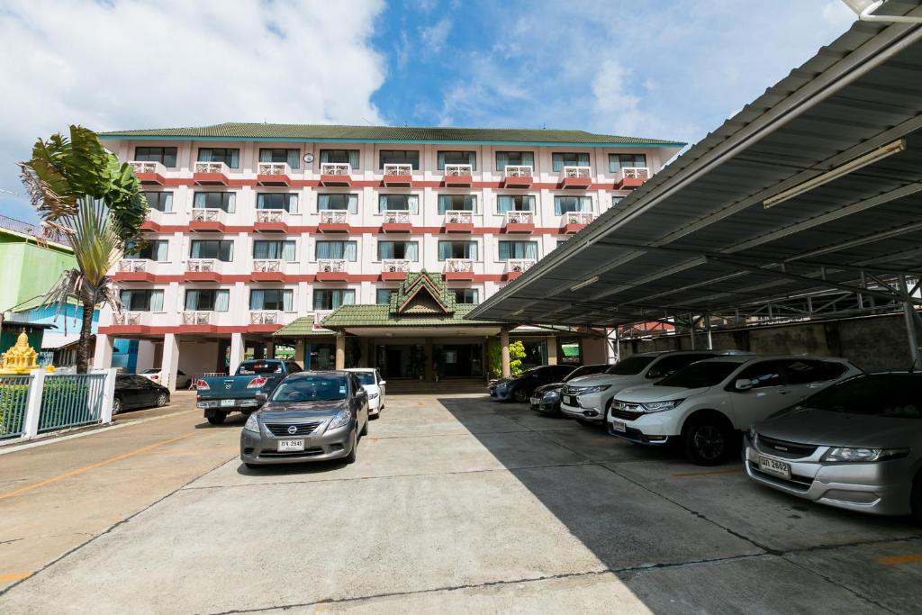 un gran edificio con coches estacionados frente a él en Tokyo Hotel, en Ubon Ratchathani