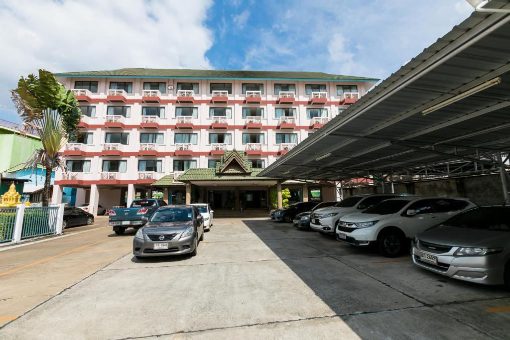 Un gran edificio con coches aparcados delante. en Tokyo Hotel, en Ubon Ratchathani