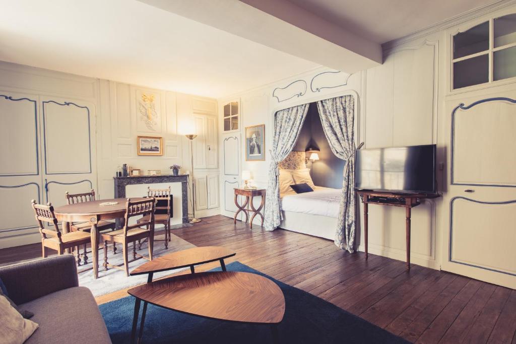 - un salon avec un lit et une table dans l'établissement La Maison de la Liberté Jean-François de La Pérouse, à Poitiers