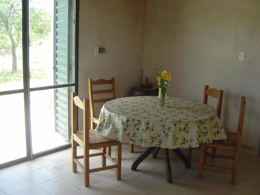 een eettafel met een vaas met bloemen erop bij Lluvia de Estrellas in Villa Giardino