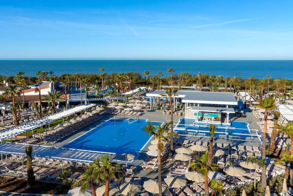 an aerial view of a resort with a pool and the ocean at Hotel Riu Chiclana - All Inclusive in Chiclana de la Frontera