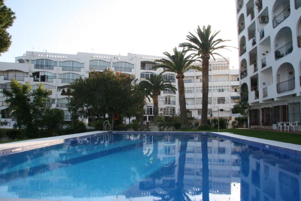 una gran piscina frente a un edificio en Verdemar Apartment with Sea View and Garden, en Nerja