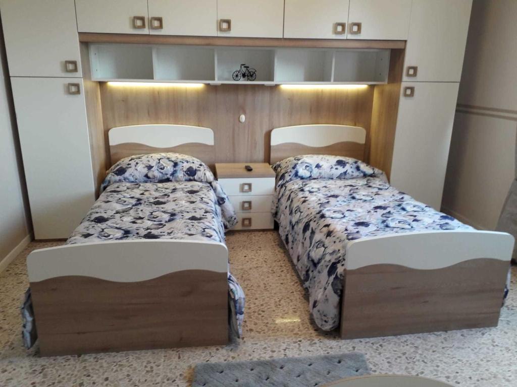 2 Betten in einem kleinen Zimmer mit 2 Schlafgelegenheiten in der Unterkunft CASA CELESTE in Ponte San Pietro