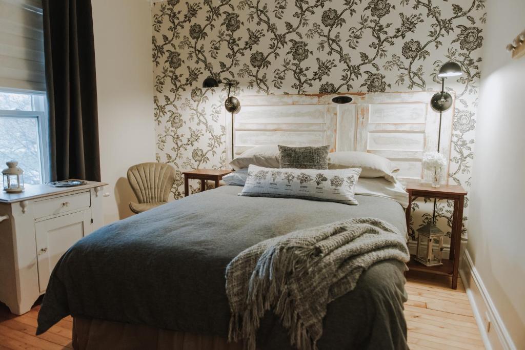 a bedroom with a bed with a patterned wall at Tranquil Days Guest House in Stratford