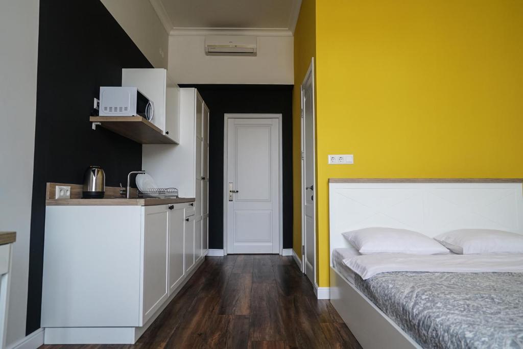 リヴィウにあるHOTEL N°10の黄色の壁のベッドルーム1室