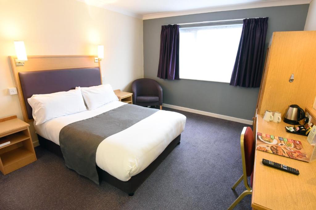 um quarto de hotel com uma cama e uma janela em Royal Oak by Greene King inns em Bromborough