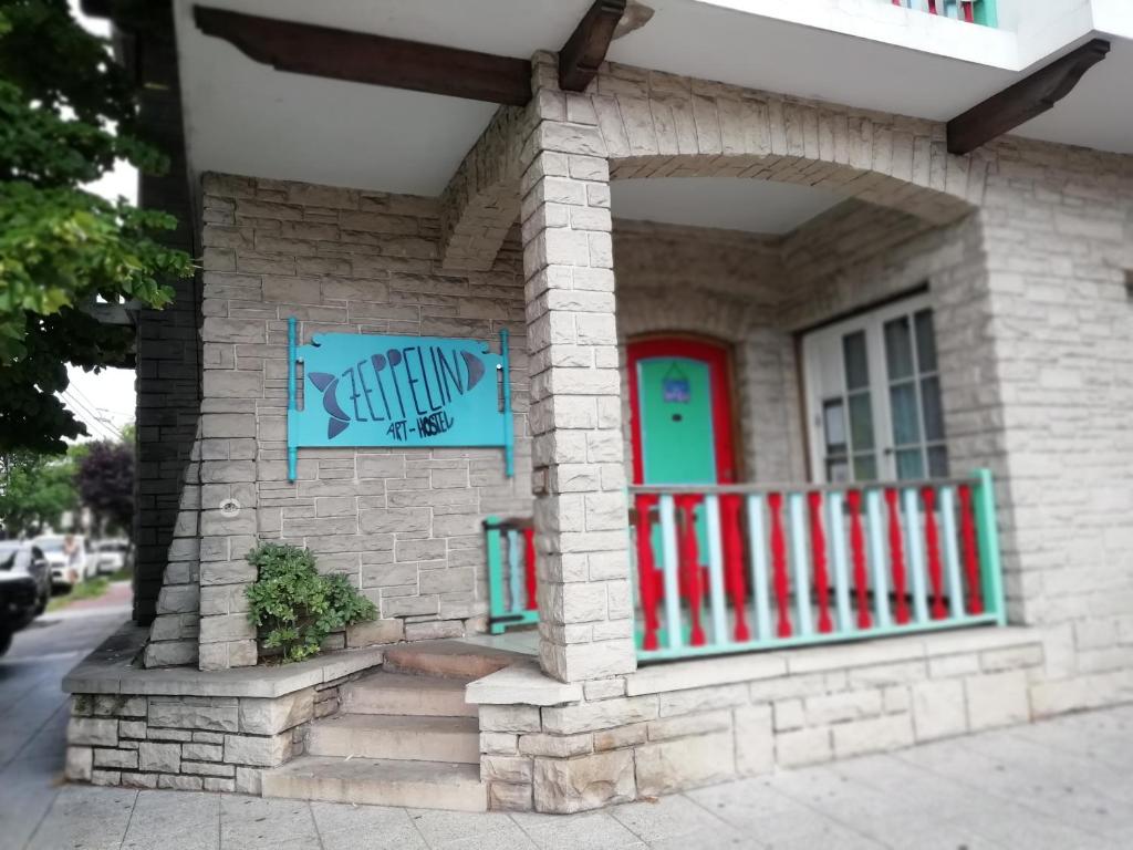 a brick house with a red door and a window at Zeppelin Art-Hostel in Mar del Plata