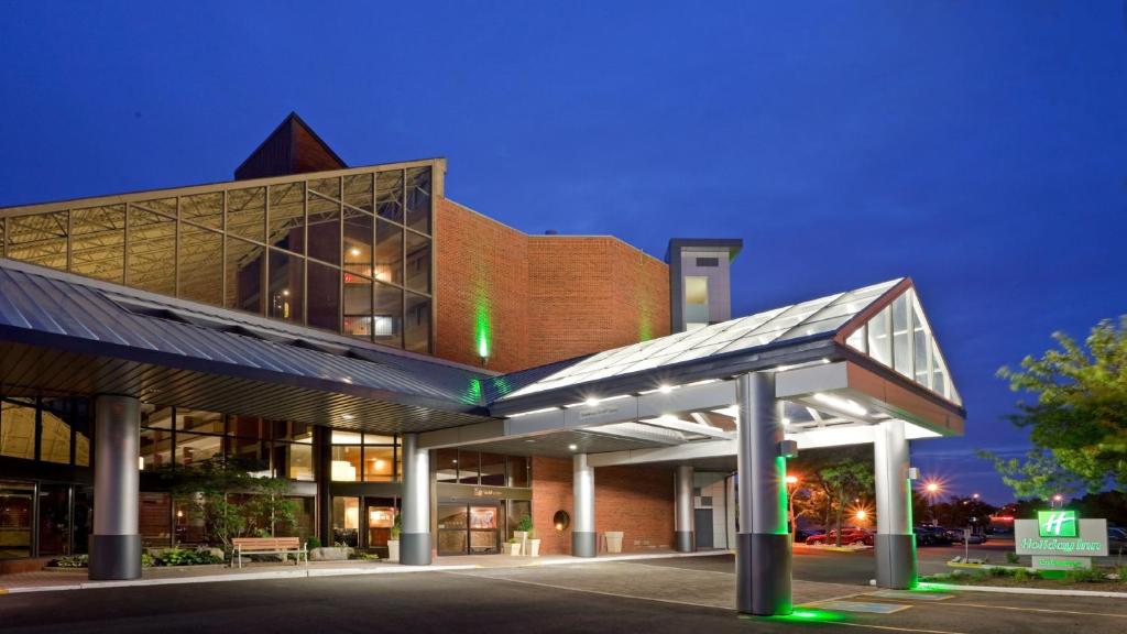 un grande edificio con facciata illuminata di notte di Holiday Inn Oakville Centre, an IHG Hotel a Oakville