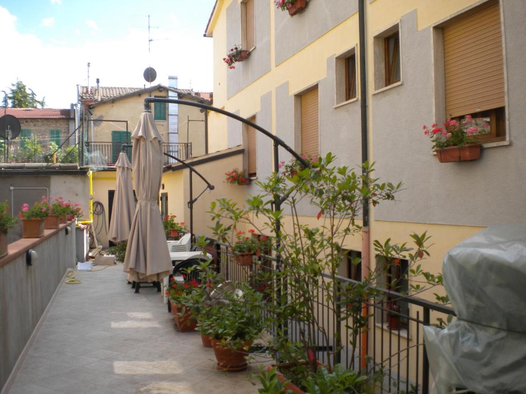 - un balcon avec des parasols et des plantes dans un bâtiment dans l'établissement Albergo Ristorante Pizzeria La Bocca di Bacco, à Abbadia San Salvatore
