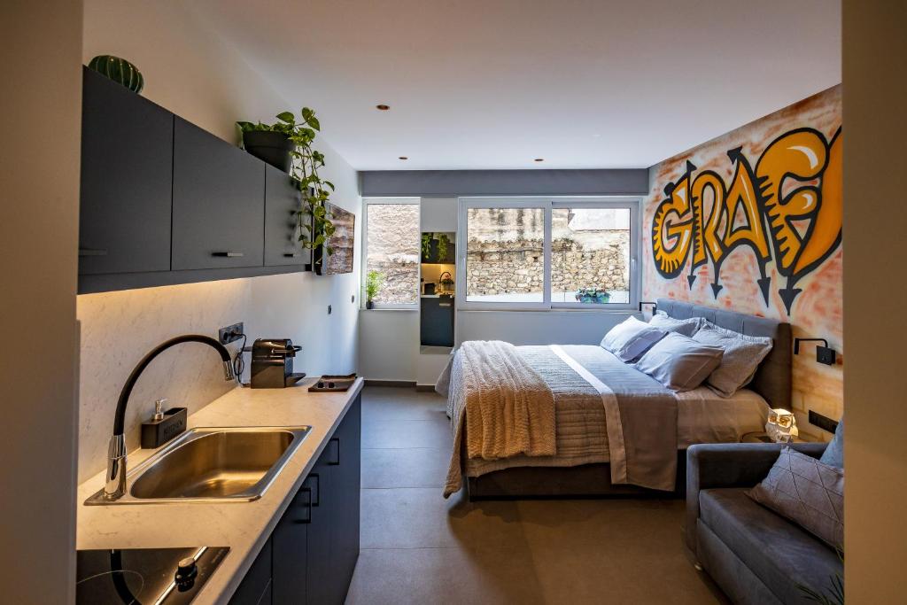 a kitchen with a bed and a sink in a room at Triple A - Graffiti Homage in Psirri Square - FREE Parking! in Athens