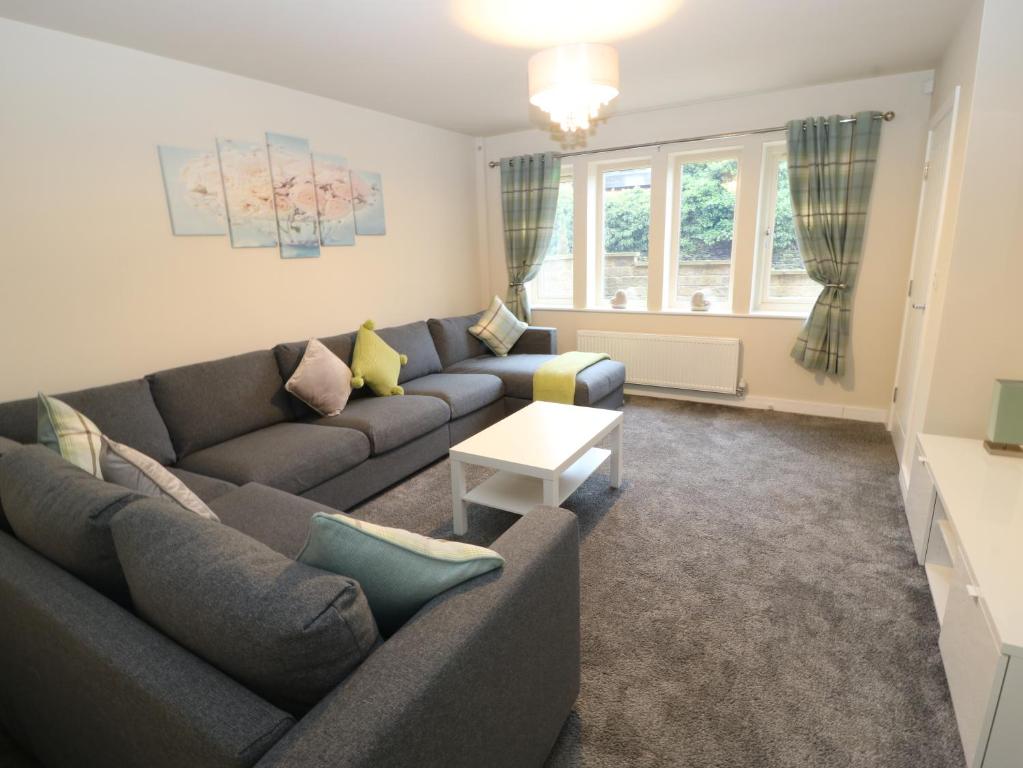 a living room with a couch and a table at Modern Town House Shepley in Huddersfield