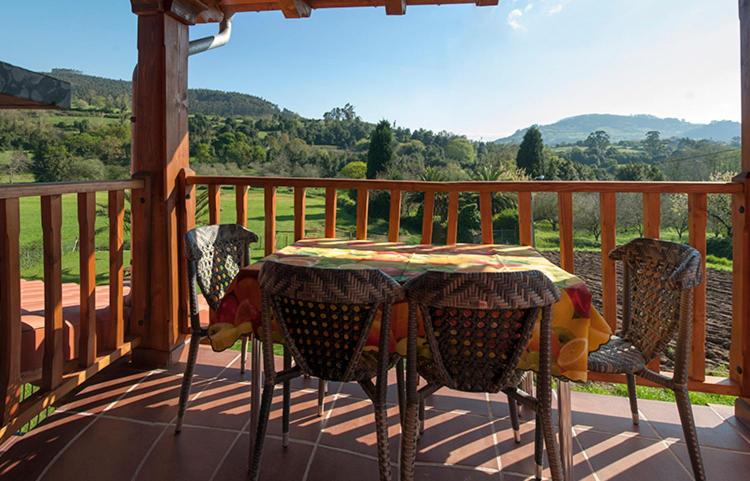 una mesa y sillas en un porche con vistas en Apartamentos Vega Rodiles el balcón, en Villaviciosa