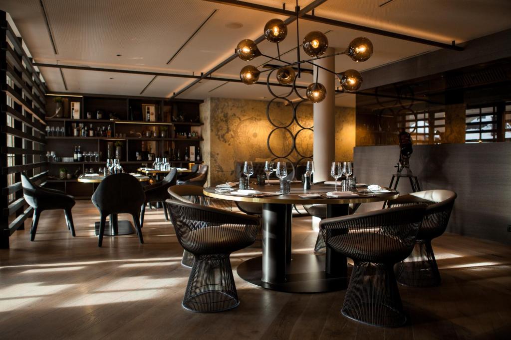 a dining room with tables and chairs and a chandelier at Schlosshotel Fiss in Fiss
